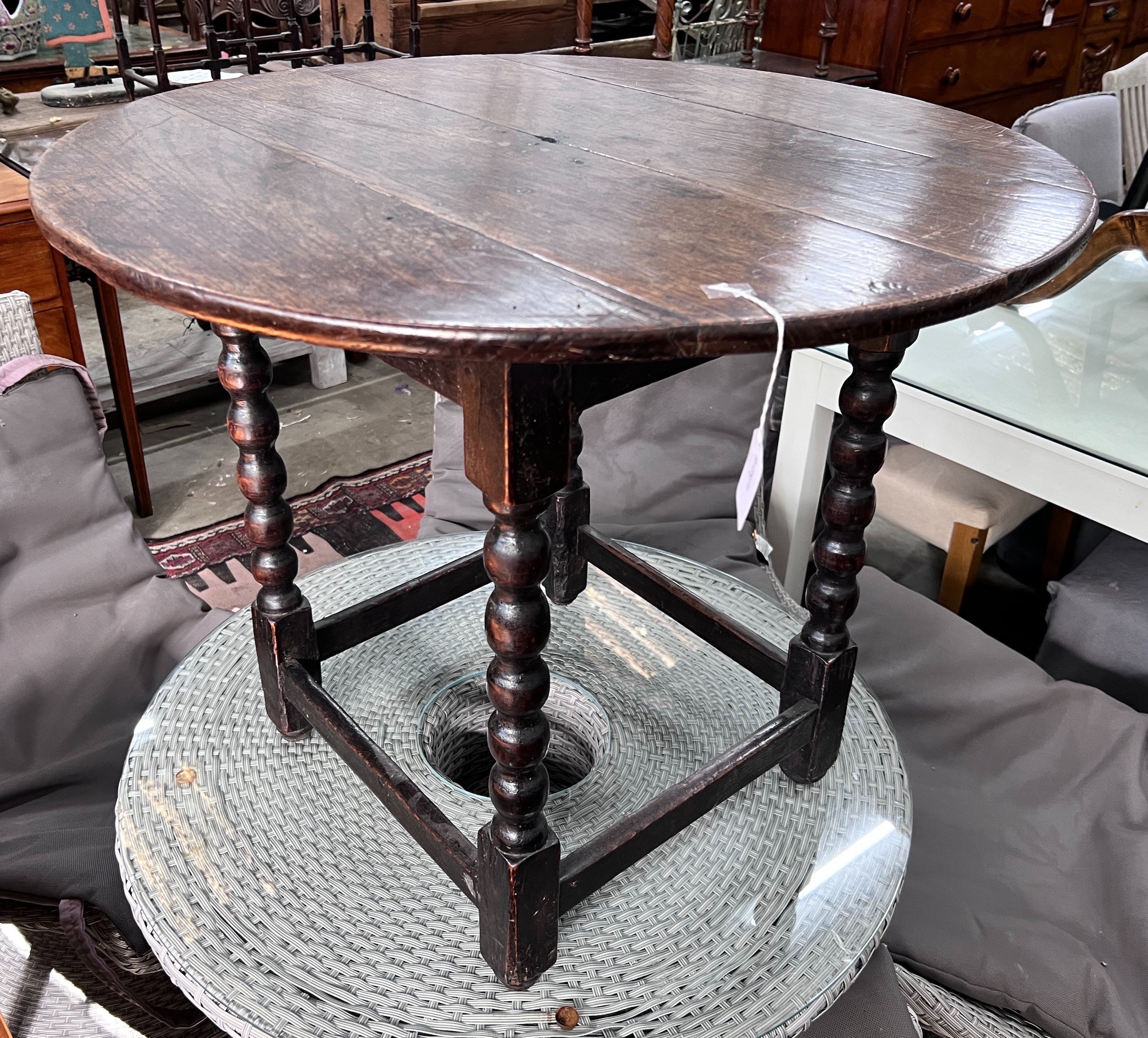 A circular oak bobbin legged table, diameter 73cm, height 61cm *Please note the sale commences at 9am.